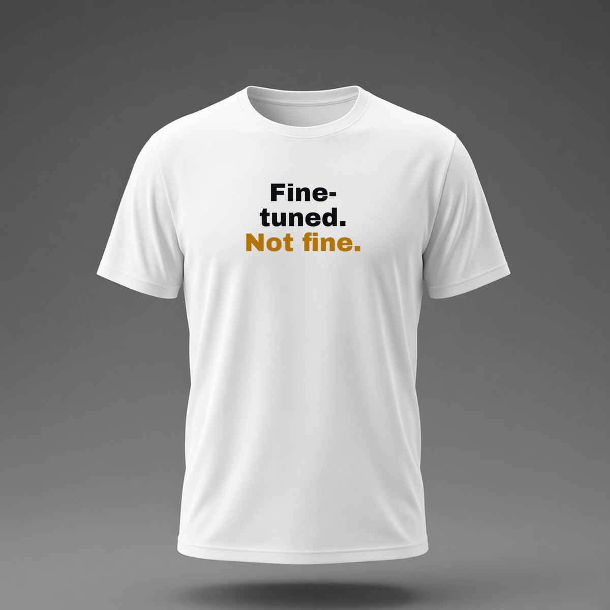 Front view: White t-shirt floating on a grey background with 'Fine-tuned. Not fine.' in three heavy lines printed across the chest in black and dark amber.