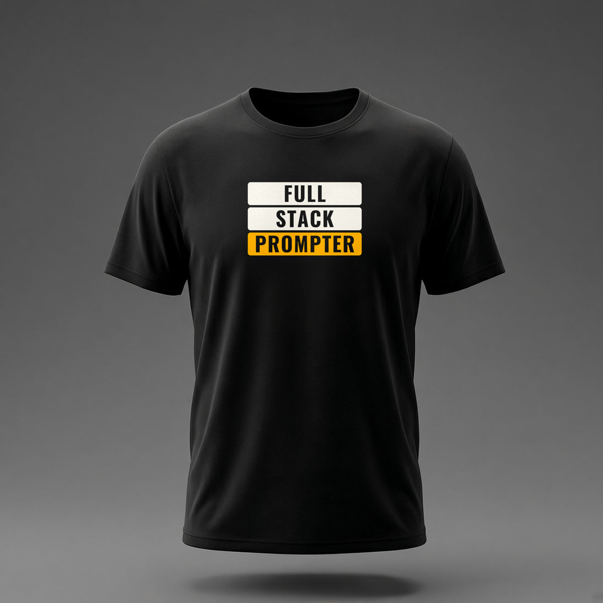 Front view: Black t-shirt floating on a grey background with 'Full Stack Prompter' as three stacked slabs with the words knocked out printed across the chest in off-white and amber.