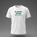 Front view: White t-shirt floating on a grey background with 'It works on my prompt.' in three heavy lines printed across the chest in black and dark green.