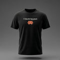 Front view: Black t-shirt floating on a grey background with a single short lowercase line of off-white text across the chest and a small coral pixel-art critter below it.
