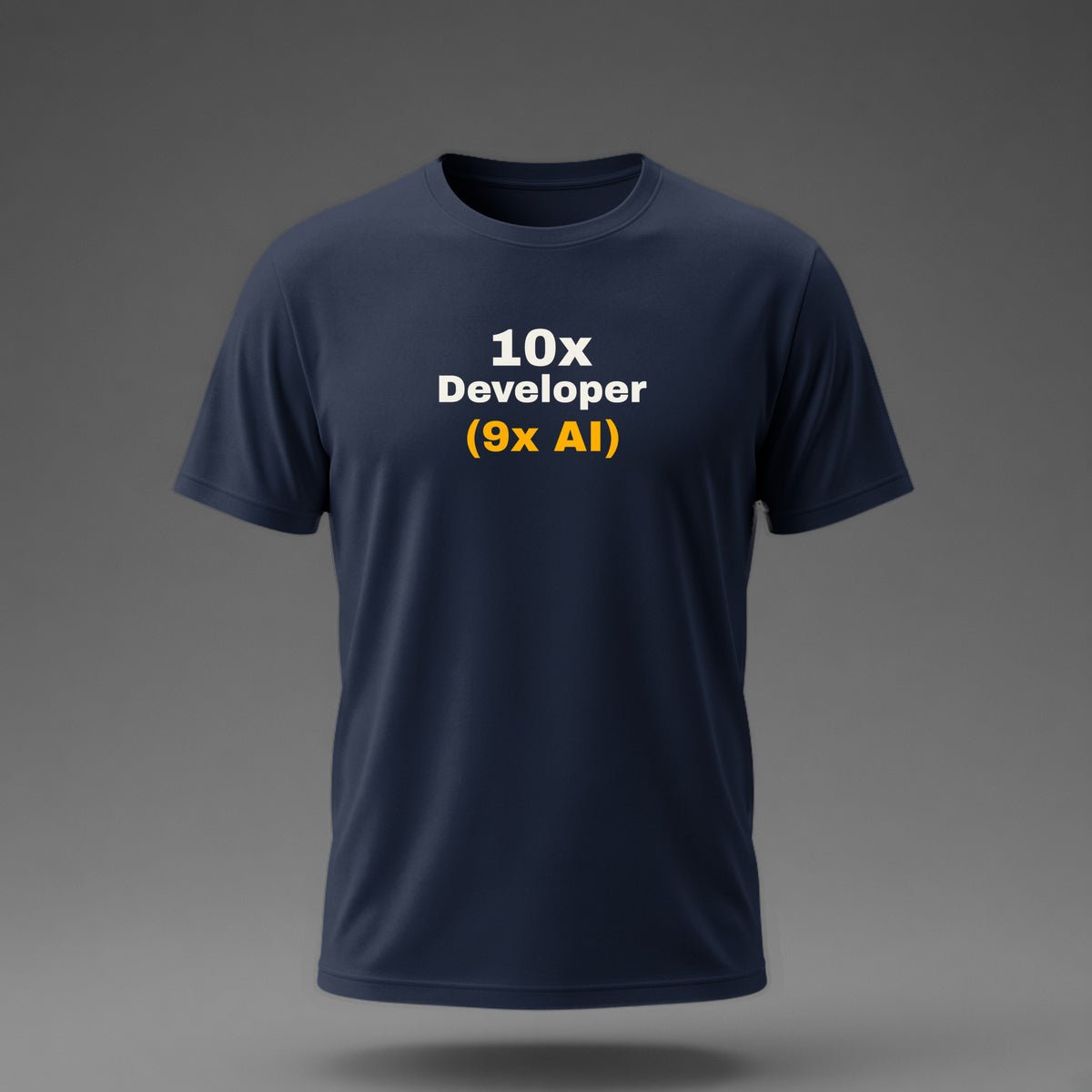 Front view: Navy t-shirt floating on a grey background with '10x Developer (9x AI)' with the footnote in amber printed across the chest in off-white and amber.