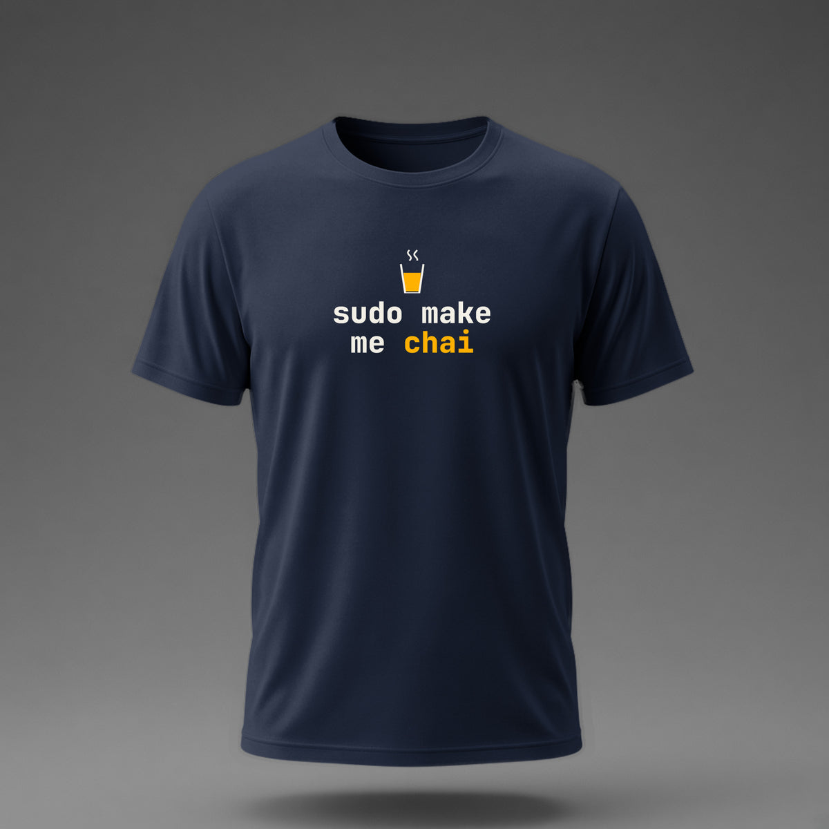 Front view: Navy t-shirt floating on a grey background with 'sudo make me chai' in two heavy mono lines under a cutting-chai glass printed across the chest in off-white and amber.
