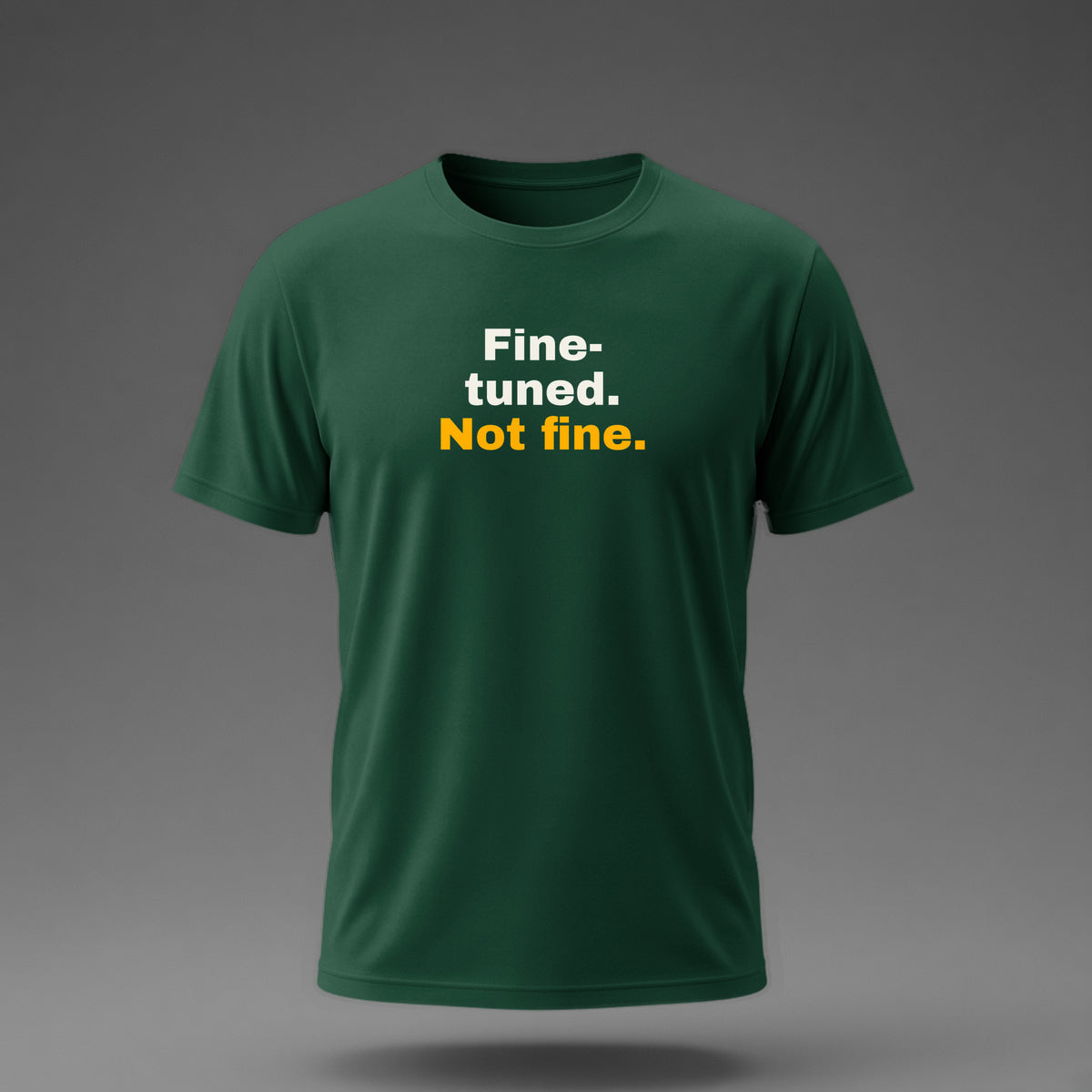 Front view: Bottle Green t-shirt floating on a grey background with 'Fine-tuned. Not fine.' in three heavy lines printed across the chest in off-white and amber.