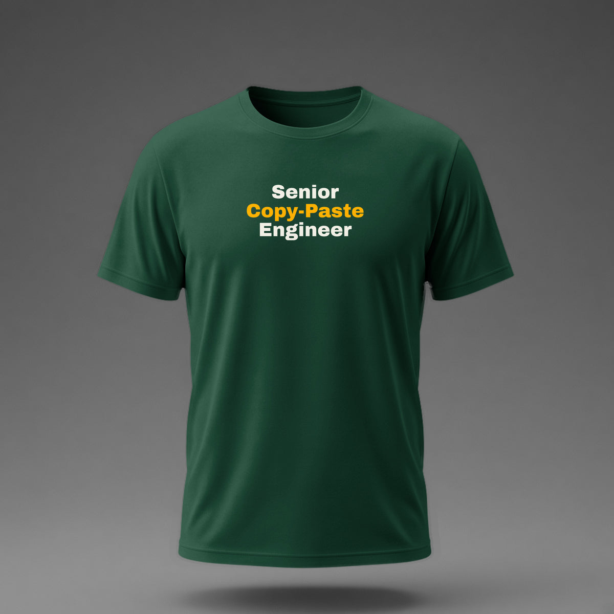 Front view: Bottle Green t-shirt floating on a grey background with 'Senior Copy-Paste Engineer' in three heavy lines printed across the chest in off-white and amber.