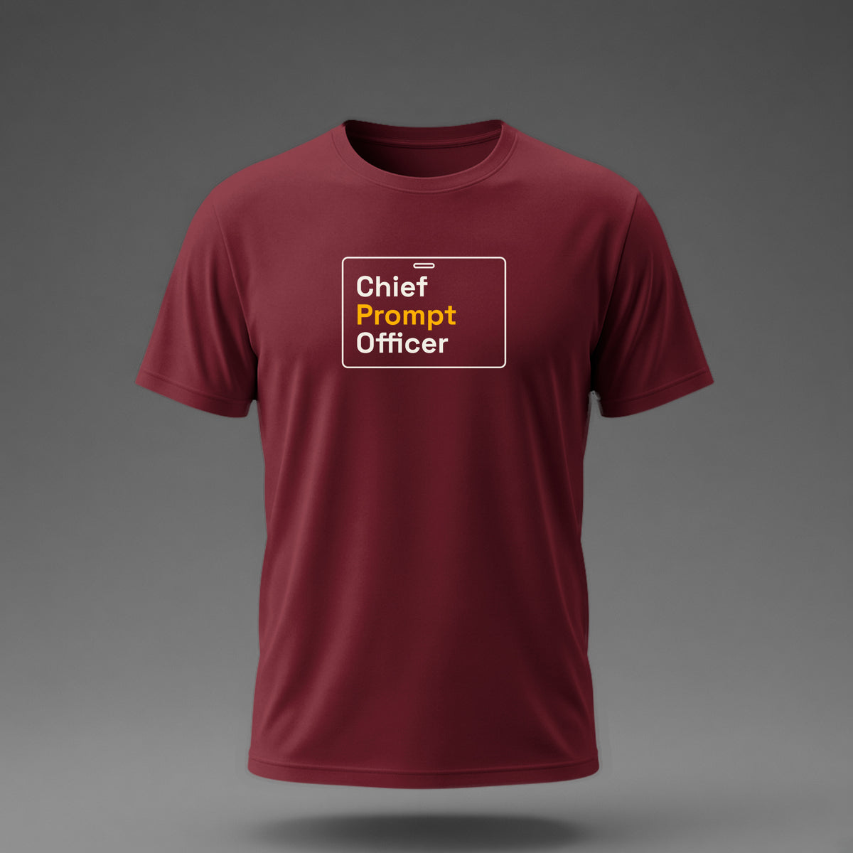 Front view: Maroon t-shirt floating on a grey background with 'Chief Prompt Officer' on an ID-badge outline printed across the chest in off-white and amber.